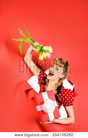 Pin Up Woman Holds Flowers&gift. Bouquet Of Flowers. Through Paper. Happy Woman Looking Through Hole