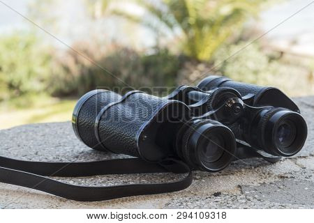 Black Binoculars Lying On The Stone In The Summer
