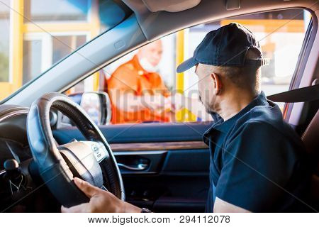 Selective Focus To The Man Driving The Car Is Paying The Expressway