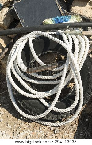 White Rope Lying On A Black Wheel And Brush