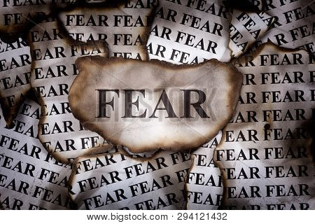 Burnt Fear. Burnt Pieces Of Paper With The Word Fear. Close-up.