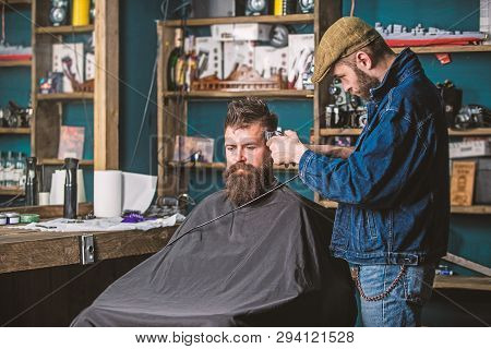 Barber With Clipper Trimming Hair On Temple Of Bearded Client. Barber With Hair Clipper Work On Hair