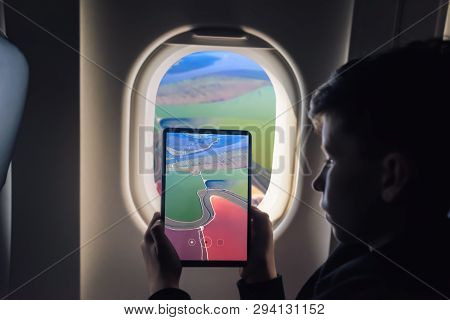 Caucasian Boy Using Tablet Pc For Taking Picture Through Plane Window Salt Ponds In Don Edwards. San