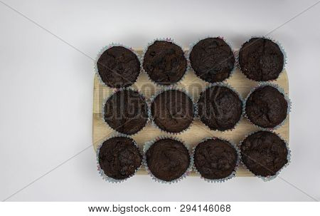Chocolate Banana Muffins On A Wooden Board Against A White Background. View From Above. Copy Space