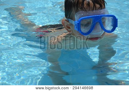 Teenager Boy Wearing Mask Swimming In The Pool. Happy Holiday Concept. Cute Happy Little Boy Swimmin