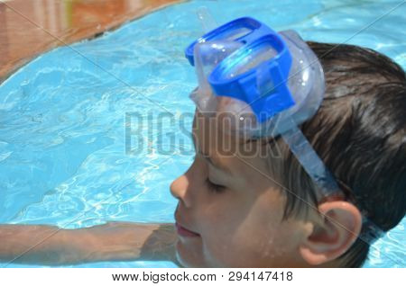 Teenager Boy Wearing Mask Swimming In The Pool. Happy Holiday Concept. Cute Happy Little Boy Swimmin