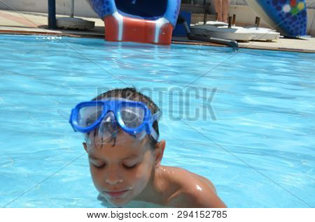 Teenager Boy Wearing Mask Swimming In The Pool. Happy Holiday Concept. Cute Happy Little Boy Swimmin