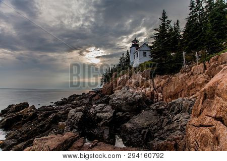 BASS HARBOR, MAINE, USA - JULY 8, 2013: Bass Harbor Lighthouse with cloudy sky overlooking Atlantic Ocean. 