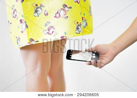 Sexual Harassment At Work. Man Taking A Photo With Mobile Phone Of Secretary's Butt