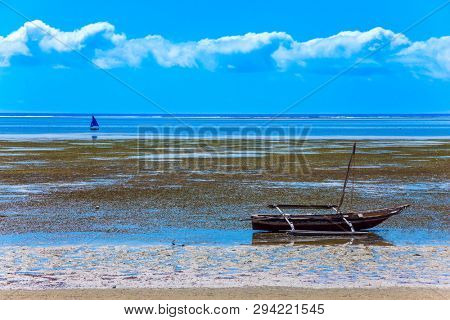 Warm Indian Ocean. Fabulous beach in Mombasa with white sand. In the ocean - low tide, the bottom is overgrown with algae. Kenya, equator. Beach holiday and photo tourism concept