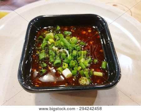 Thai Food Style, Top View Of Spicy Seafood Dipping Sauce Sprinkled With Scallion Sliced In Black Bow
