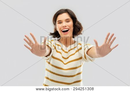 counting and people concept - happy smiling young woman in striped pullover showing ten fingers of two hands over grey background