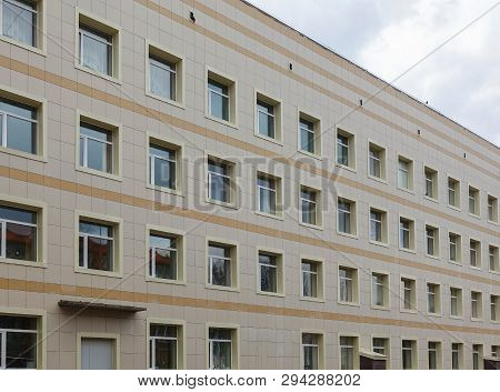 The Facade Of A Multi-storey Clinical Building. The Walls With Many Windows Are Finished With Plasti