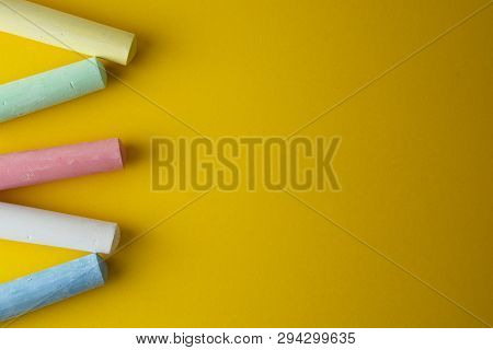 Abstract Colorful Chalks Over Yellow Background With Copy Space. Education Template. Creative Childh