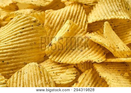 Background Of Juicy Corrugated Rounded Potato Chips Close-up