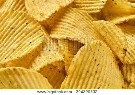 Background Of Juicy Corrugated Rounded Potato Chips Close-up
