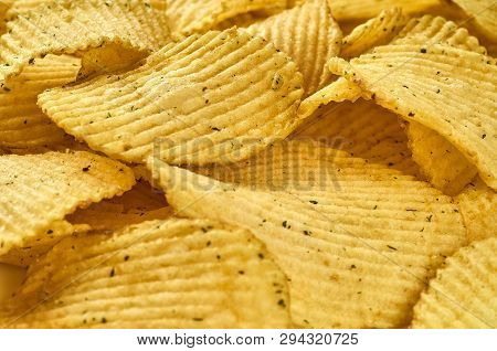 Background Of Juicy Corrugated Rounded Potato Chips Close-up