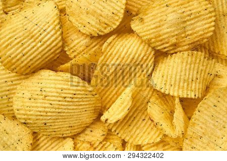 Background Of Juicy Corrugated Rounded Potato Chips Close-up