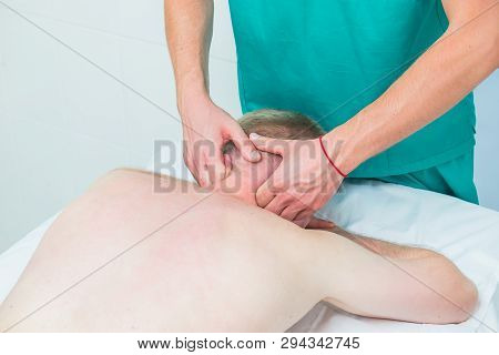 Physiotherapist Massaging Male Patient With Injured Neck Muscle. Sports Injury Treatment, Reabilitat