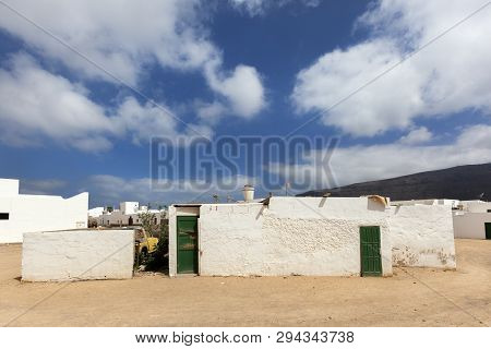 Empty Street With Sand And White Houses And A Boat In Caleta De Sebo On The Island La Graciosa Of La
