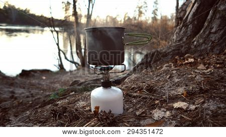 Close-up Of A Gas Burner, On Which A Kettle With A Lid Stands, Boils Water, Steam, Cooking In Outdoo