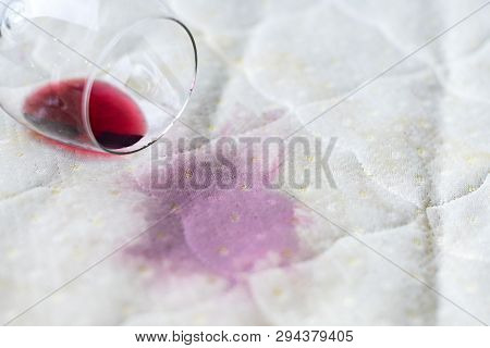 Wine Glass Spilled On Bed. Dropped Wineglass On White Bed Sheet. Pink Wet Stain. Unlucky, Unfortunat