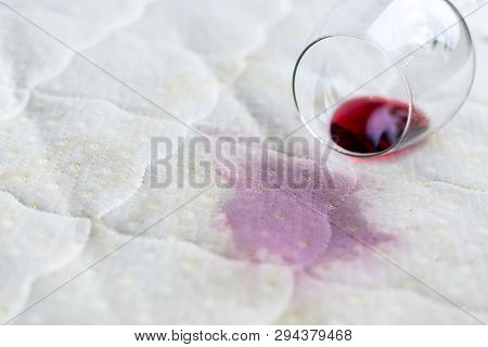 Wine Glass Spilled On Bed. Dropped Wineglass On White Bed Sheet. Pink Wet Stain. Unlucky, Unfortunat