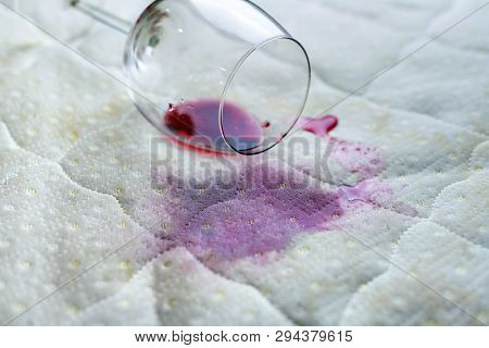 Wine Glass Spilled On Bed. Dropped Wineglass On White Bed Sheet. Pink Wet Stain. Unlucky, Unfortunat