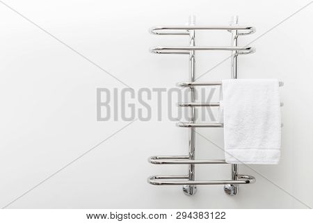 Modern Bathroom Towel Dryer On White Wall Background With Copy Space