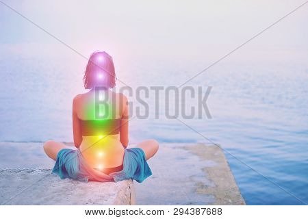 Portrait Of Young Beautiful Woman Sits In A Pose Of Half Lotus Practicing Yoga Meditation At Blue Su