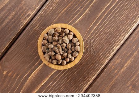 Lot Of Whole Brown Clay Pebbles (leca) With Wooden Bowl Flatlay On Brown Wood