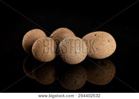 Group Of Five Whole Brown Clay Pebbles (leca) Isolated On Black Glass