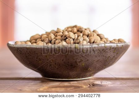 Lot Of Whole Brown Clay Pebbles (leca) On Grey Ceramic Plate In A Room With Spanish Window