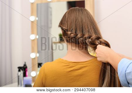 Professional Coiffeuse Braiding Client's Hair In Salon