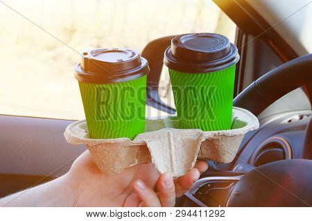 Two Green Paper Cups With Tea Or Coffee  In A Male Hand In Car On Sunny Blurred Background. Takeaway