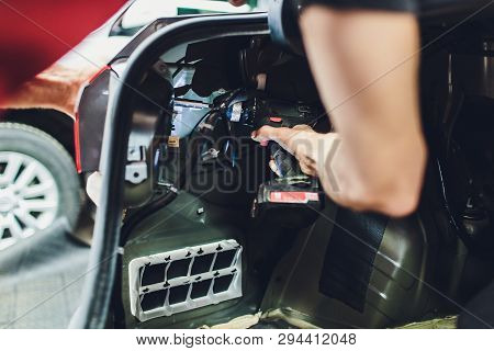 Mechanic Matching Automobile Headlight Lamp To Damaged Car At Repair Service Station.