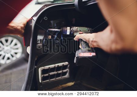 Mechanic Matching Automobile Headlight Lamp To Damaged Car At Repair Service Station.