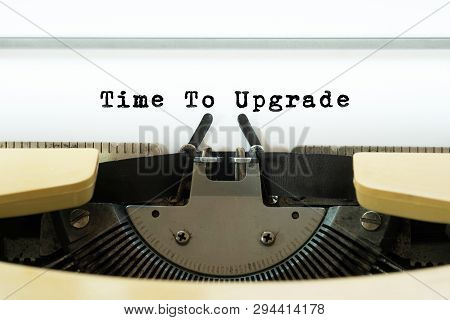 Time To Upgrade Word Typed On A Yellow Vintage Typewritter. Business Concept.