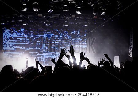 Crowd On Music Show, Happy People With Raised Hands. White Stage Light. Frontman On Stage.