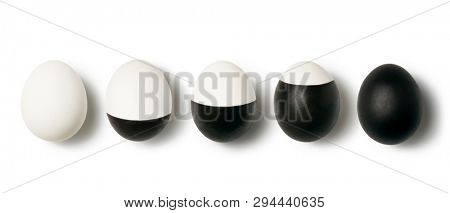 Pattern with row from eggs white and black painted on a white background with place for text. Top view. Concept of dualism yin and yang.