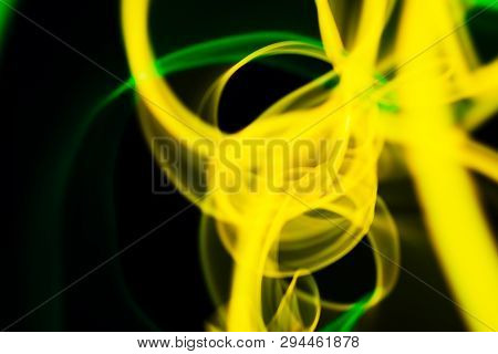 Yellow And Green Neon Lines Abstraction. Neon Lights. Isolated On Black Background. Modern Art.