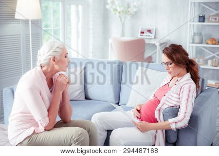 Loving Grey-haired Mother Giving Some Advice To Pregnant Daughter