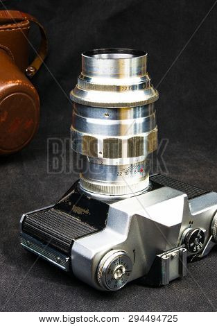 Old Soviet Film Slr Camera With Original Leather Case On Black Background