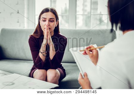 Young Woman Feeling Thoughtful Sharing Problems With Psychologist