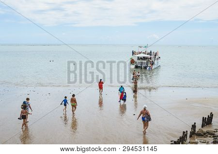 Joao Pessoa - Pb, Brazil - February 21, 2019: Tourists Entering The Sea To Reach The Catamaran At Be