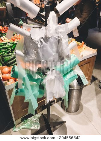 Stand With Many Single Use Plastic Bags In Supermarket At Vegetables. Ban Single Use Plastic. Rolls