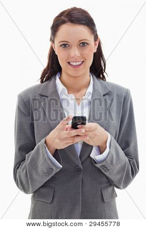 Close-up of a businesswoman smiling and holding her mobile against white background