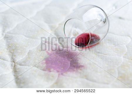 Wine Glass Spilled On Bed. Dropped Wineglass On White Bed Sheet. Pink Wet Stain. Unlucky, Unfortunat