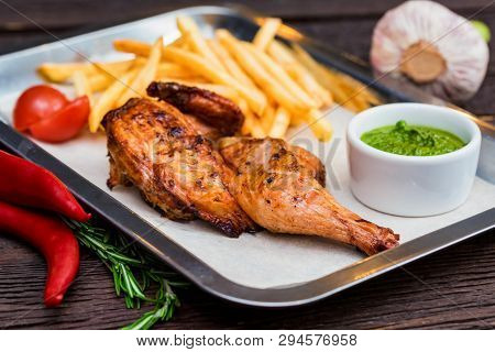 Close Up Meal With Chicken Thigh, French Fries, Chili Pepper And Garlic