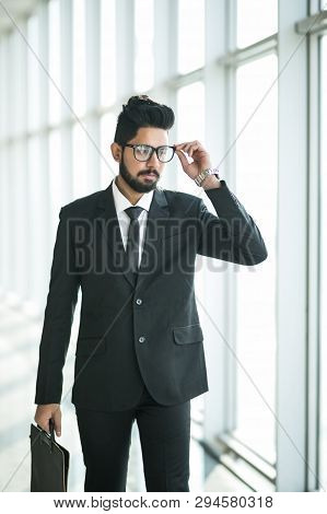 Indian Businessman Walking In Office Interior With Big Windows With View On The Business Center